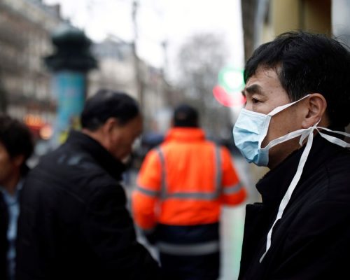 Um turista usa uma máscara protetora em frente à loja de departamentos Galeries Lafayette, em Paris, quando o país é atingido pelo novo coronavírus, na França, em 30 de janeiro de 2020.